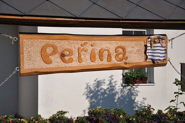 Ručně vyřezávaná cedule Peřina nad vchodem